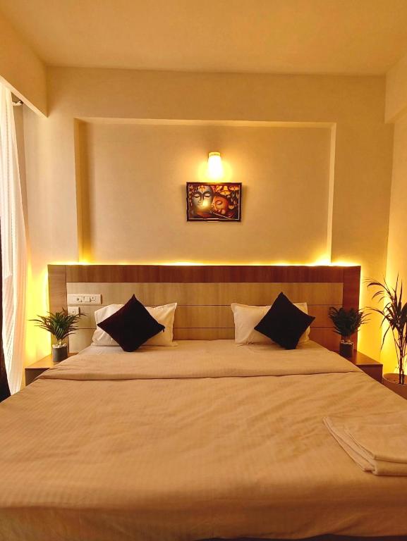 a bedroom with a large bed with two pillows at Peaceful Stay at Vrindavan in Vrindāvan