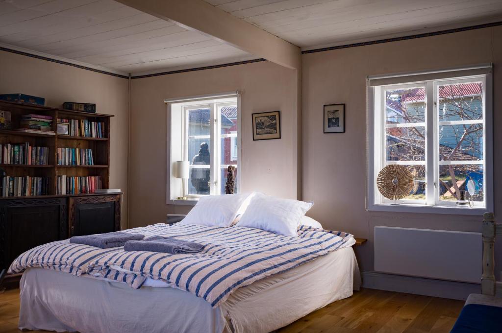 a bedroom with a bed and two windows at Remarkable Harbour View Cabin. in Östhammar