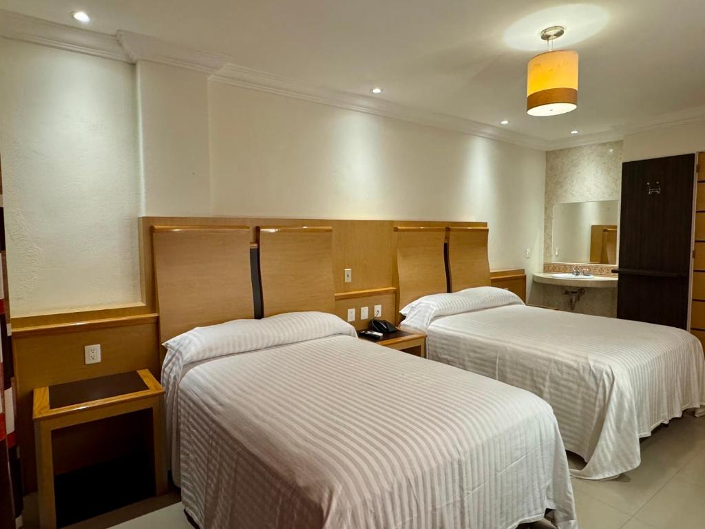 a hotel room with two beds in a room at Hotel Nilo in Acapulco