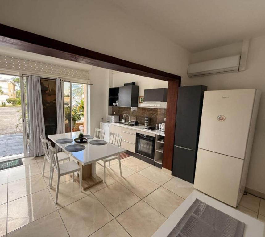 a kitchen with a table and a white refrigerator at Paradise01 in Les Terres Basses
