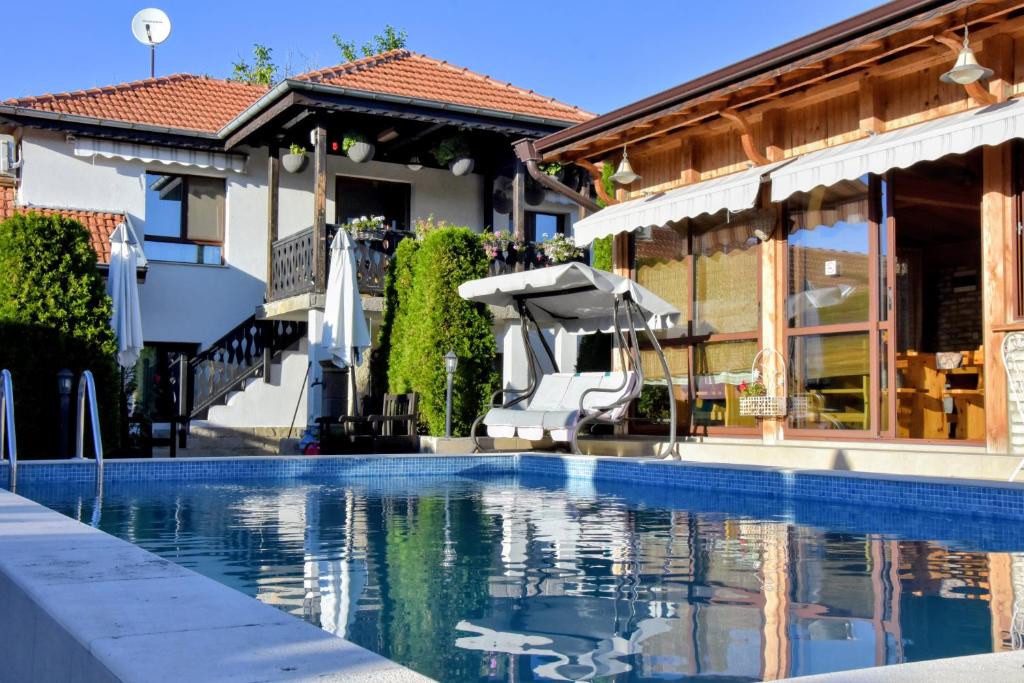 a swimming pool in front of a house at Guest house Zlateya in Madara