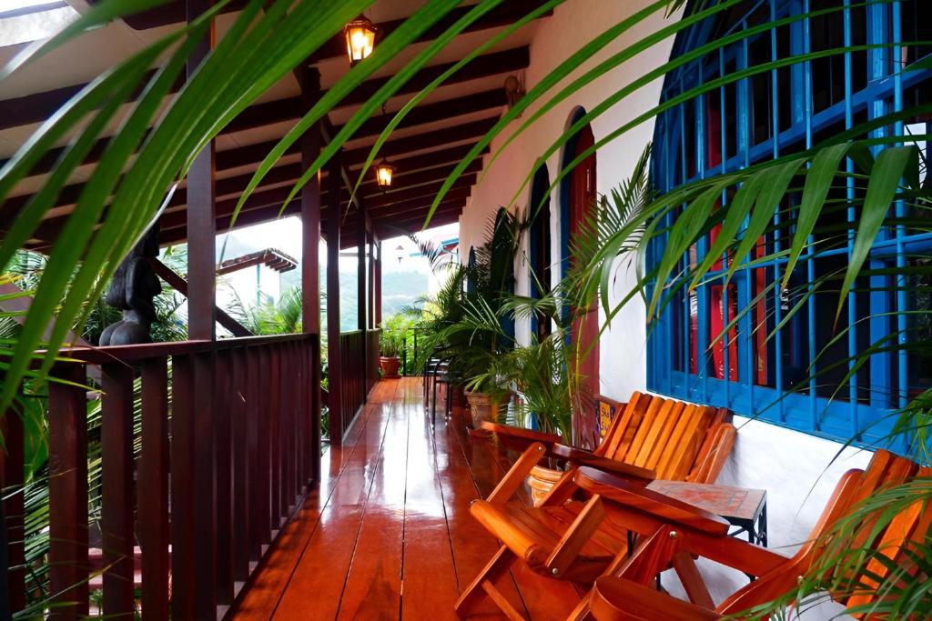 a porch with benches and plants on a building at Orosi Lodge in Orosí