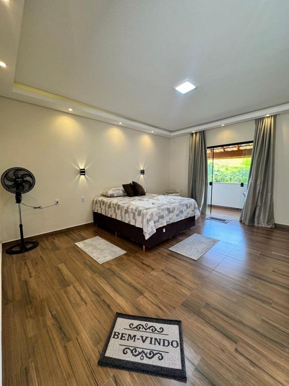 a bedroom with a bed and a wooden floor at Suítes Mazzioni in Socorro
