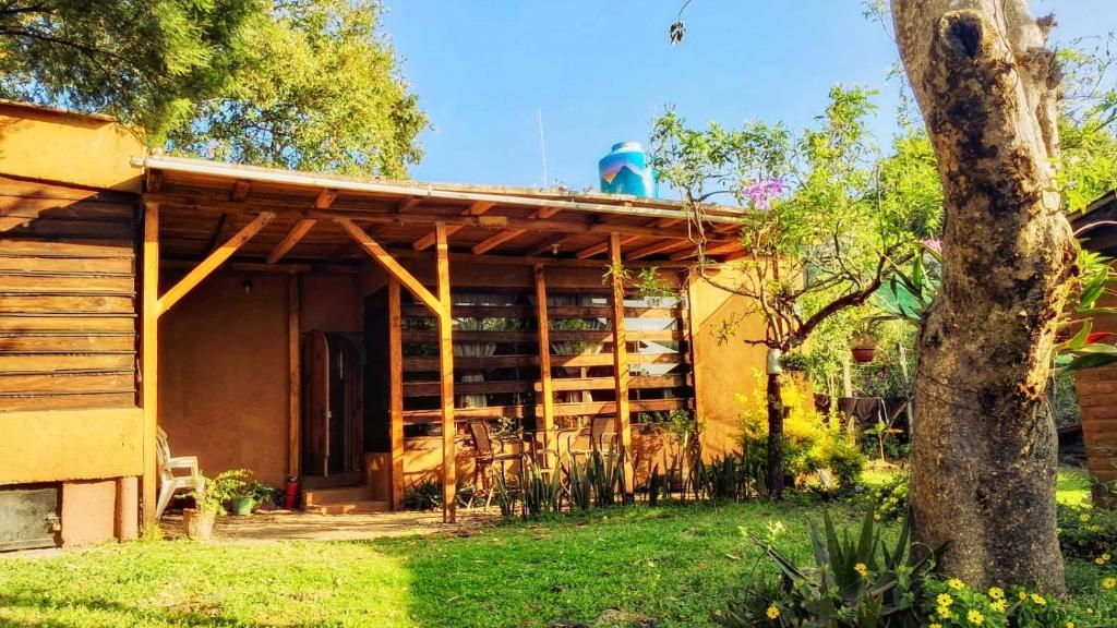 a house with a wooden roof on top of it at La Troje Cabañas in Tepoztlán