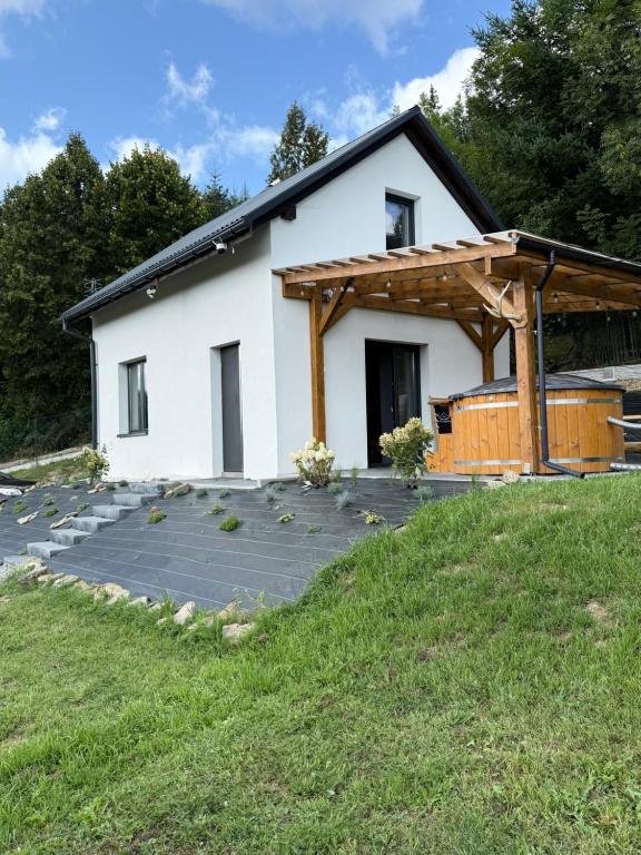 a white house with a patio in front of it at Domek Nad Rykowiskiem in Jeleśnia