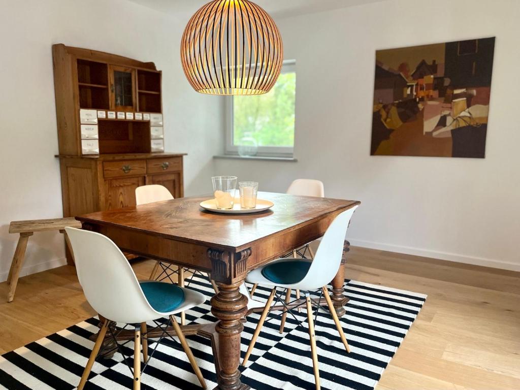 a dining room table with white chairs and a chandelier at Ferienwohnung IMMI in Ruhpolding