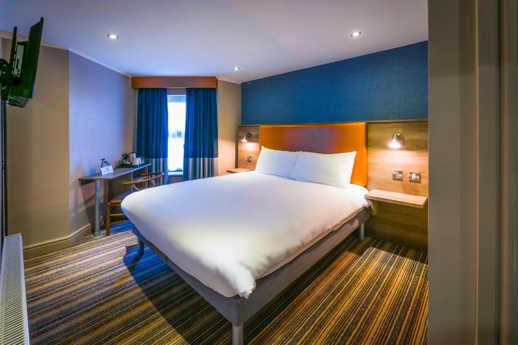 a hotel room with a large bed and a large window at ibis Styles Birmingham Hagley Road in Birmingham