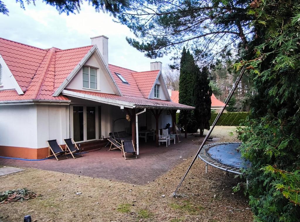 a house with a red roof and a swing at AURA House in Krępa