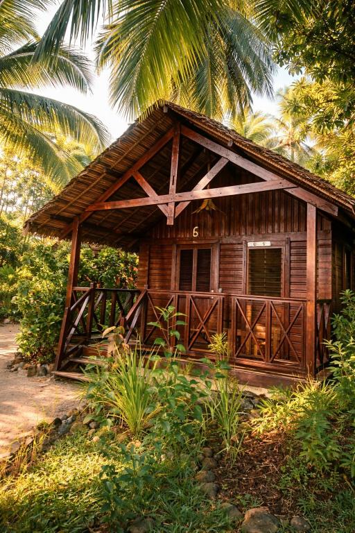 a small wooden house with a thatched roof at Le Moya Beach in Nosy Be