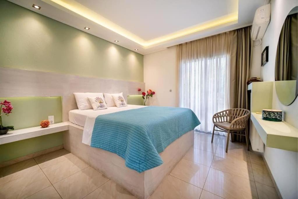 a bedroom with a bed and a table and a chair at Central Thassos luxury Apartment 4u in Limenas
