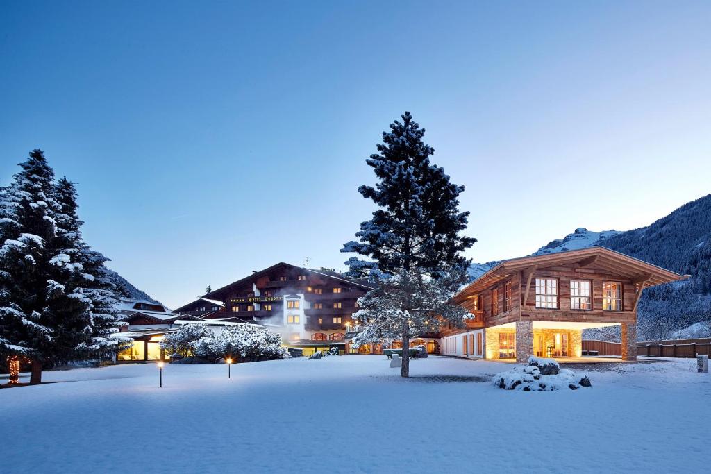 una tenuta nella neve con un cortile coperto di neve di Relais&Châteaux Spa-Hotel Jagdhof a Neustift im Stubaital