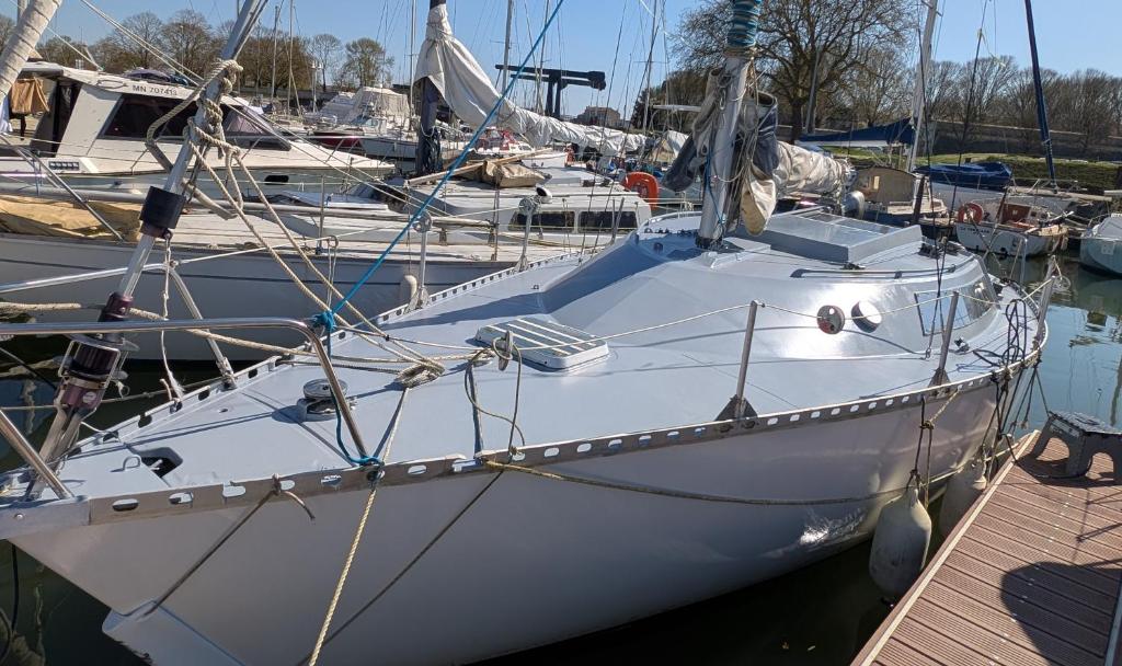 a white boat is docked at a dock at Bateau Voilier Rochefort in Rochefort