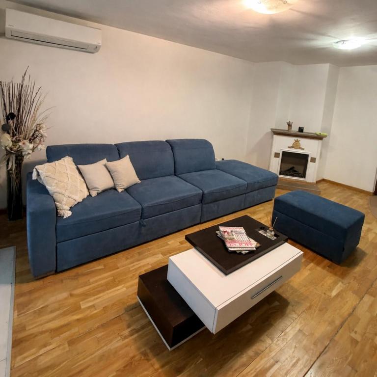 a living room with a blue couch and a table at Pasha House in Belgrade