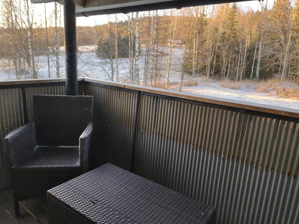 a chair and a table on a balcony with a window at Älgklinten with type 2 charger in Brograngen
