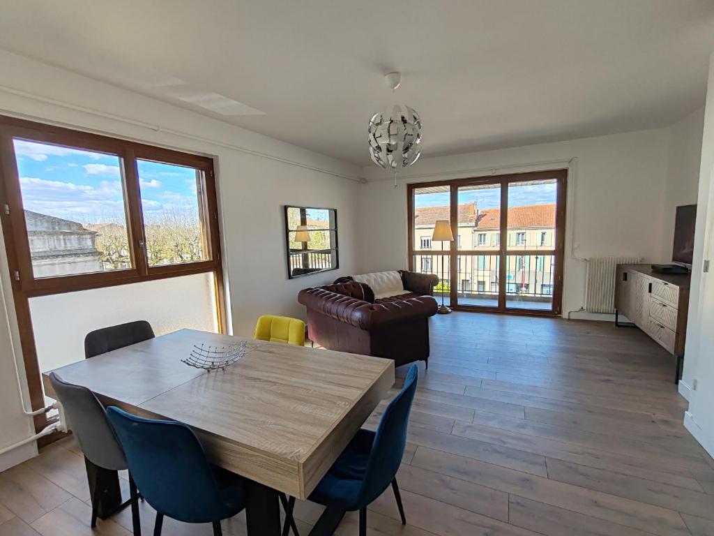 a living room with a table and a couch at Les toits du Lot in Villeneuve-sur-Lot