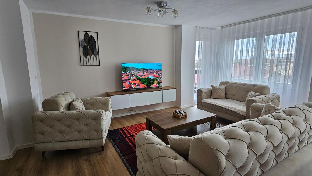 a living room with two couches and a flat screen tv at HTH Apartments in Center of Gjakova - 4th Floor in Gjakove