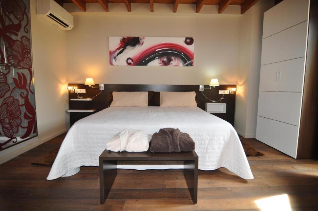 a bedroom with a large bed and a table at Resataurant and Rooms Cabrit in Sant Mateu