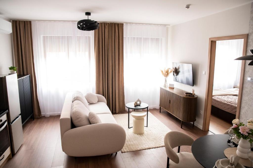 a living room with a couch and a bed at Alma Suites Győr in Győr