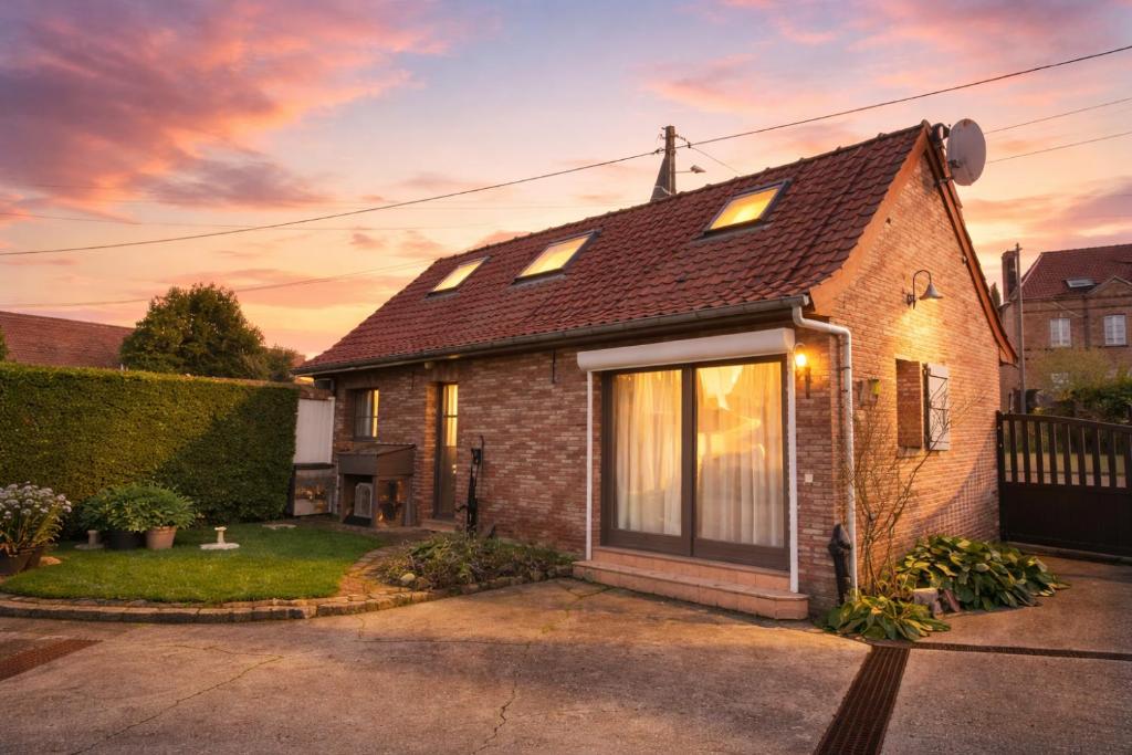 a brick house with a sunset in the background at Les Champs d'Opale in Bréxent-Énocq