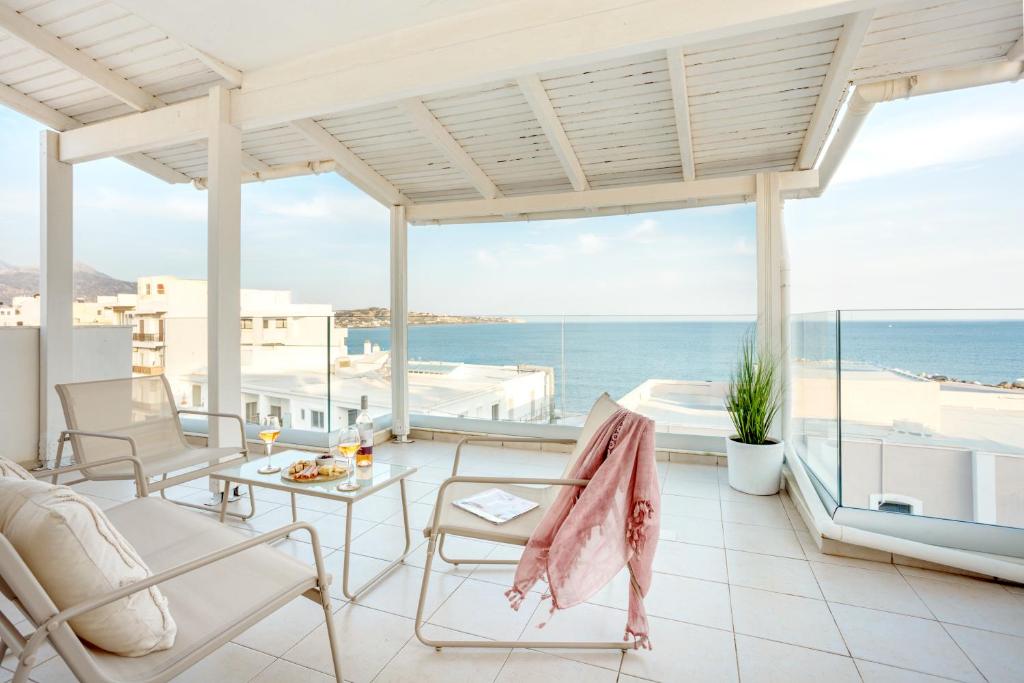 a living room with a view of the ocean at Coral Hotel - Hotelia Hospitality Group in Ierapetra