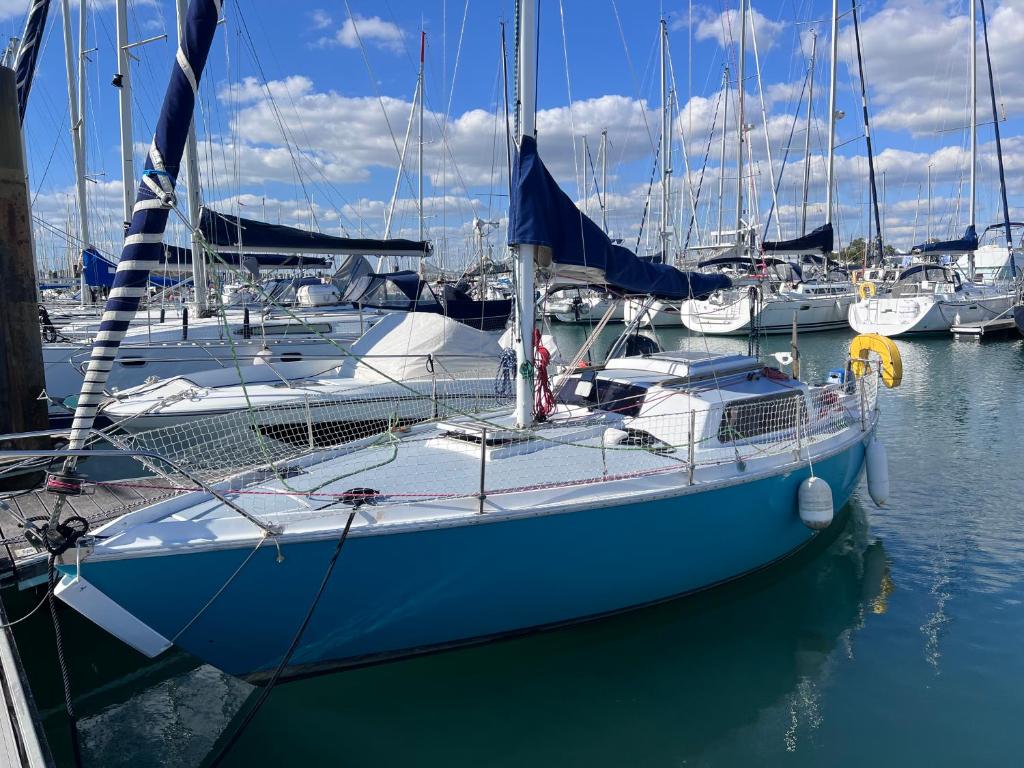 a blue boat docked in a harbor with other boats at Voilier Bateau Rochefort in Rochefort