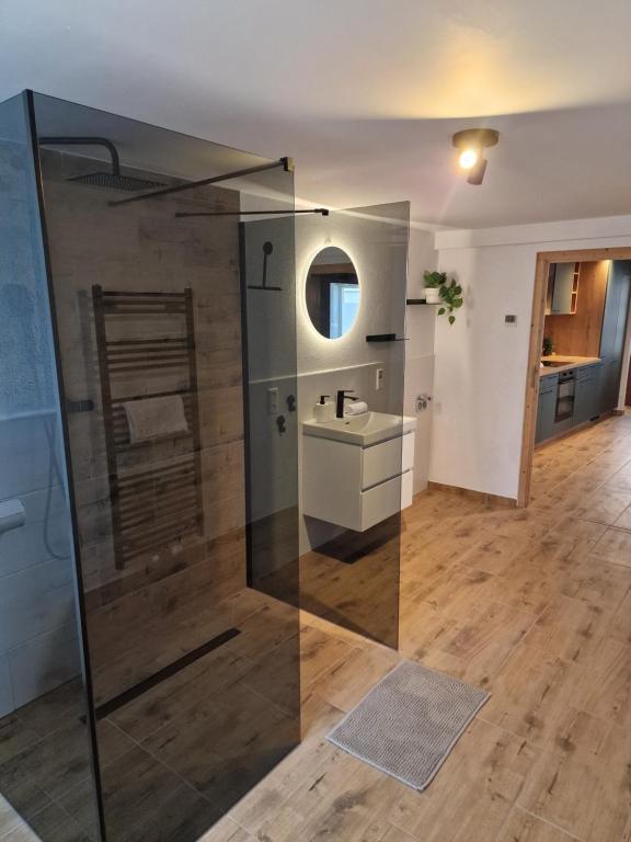 a bathroom with a glass shower and a sink at Old City Apartment Möckmühl in Möckmühl