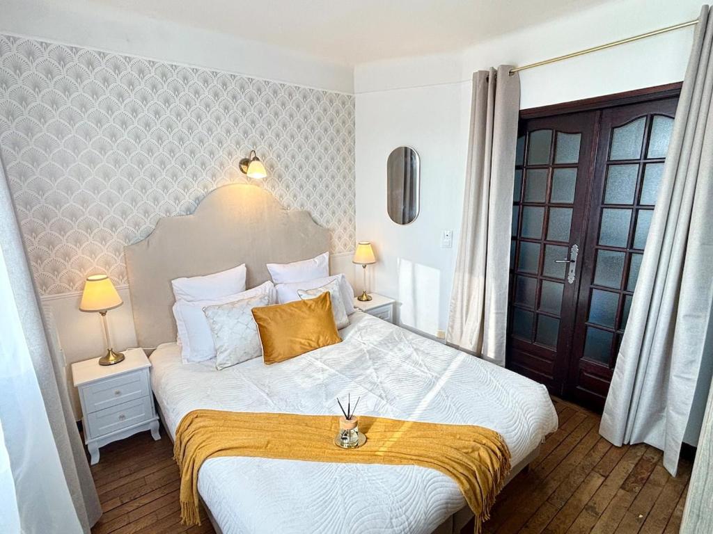 a bedroom with a large bed with a yellow blanket at Le petit Versailles in Versailles