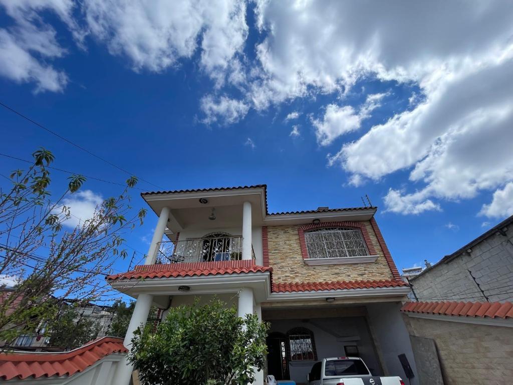 a house with a balcony and a blue sky at Amazon Jade Hotel Boutique in San Bartolomé Milpas Altas