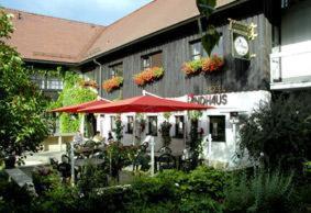 ein Restaurant mit einem roten Regenschirm vor einem Gebäude in der Unterkunft Hotel Landhaus Moritzburg in Moritzburg