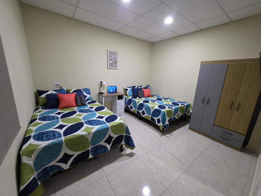a bedroom with two beds and a cabinet in it at Room #2 donde Alice in San Miguel