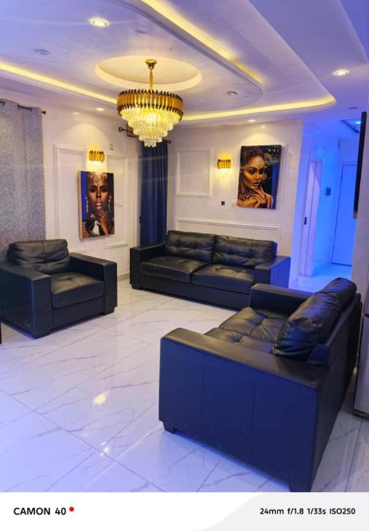 a living room with couches and a chandelier at Ngalle guest house in Buea