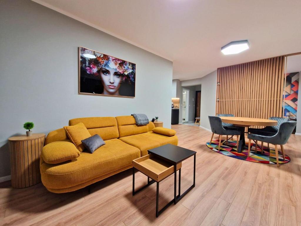 a living room with a yellow couch and a table at By The Pool Apartments #8 in Velingrad