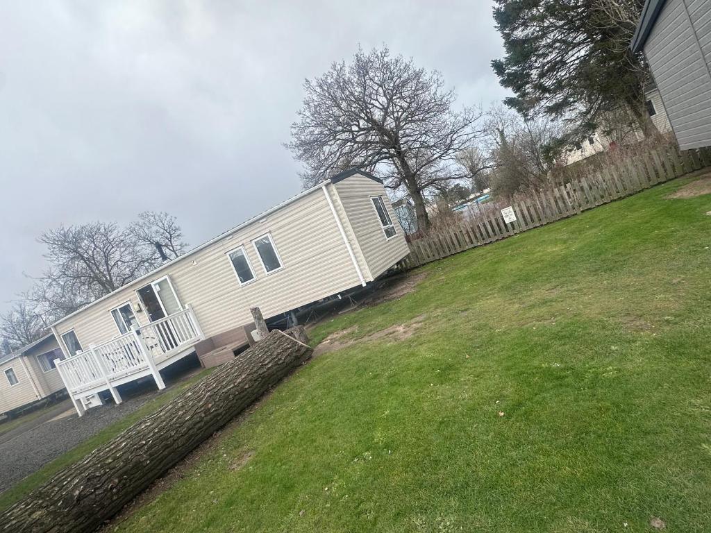 a home with a fence and a yard with a house at Riverside 24 - Haggerston Castle in Berwick-Upon-Tweed