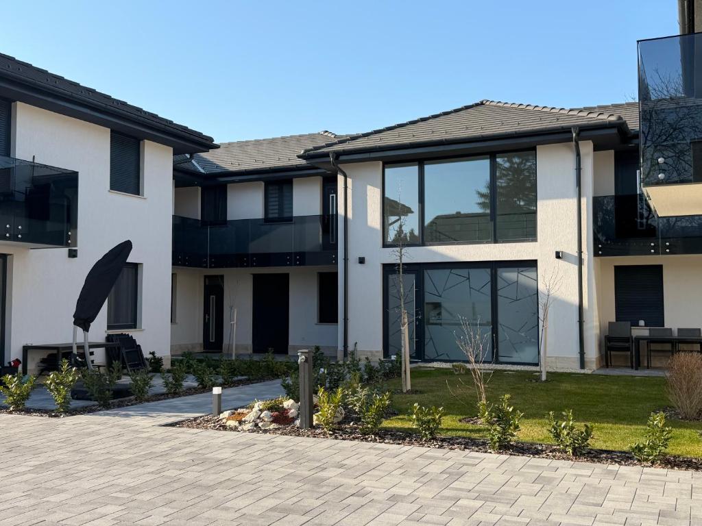 a house with glass windows and a courtyard at Minimál Éden in Balatonlelle