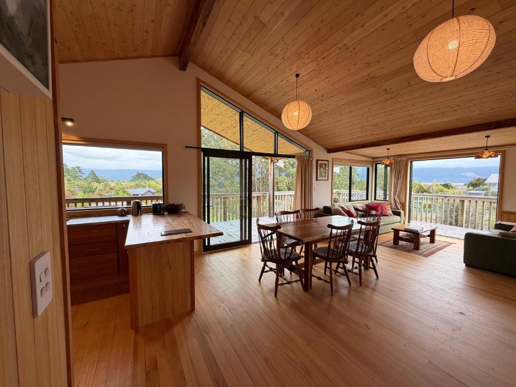 a kitchen and dining room with a table and chairs at Whare Aorere in Collingwood