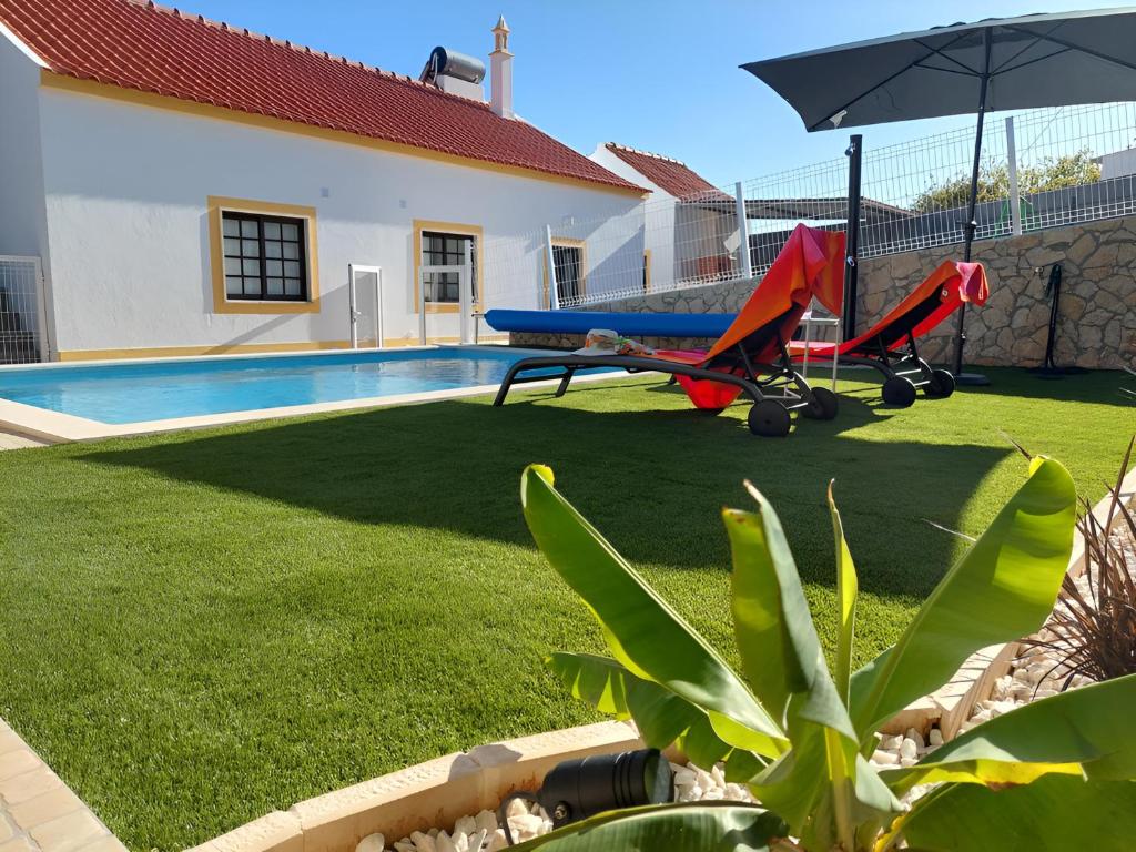 a backyard with a pool and an airplane and an umbrella at Casa Oliveira in Silves
