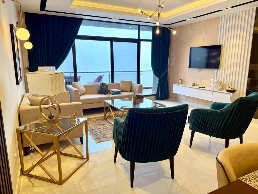 a living room with a couch and a table and chairs at Premium Murree Apartment With Stunning Views in Murree