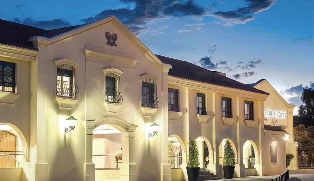 a large white building with arches on a street at Chateau Montchenot in Maipú