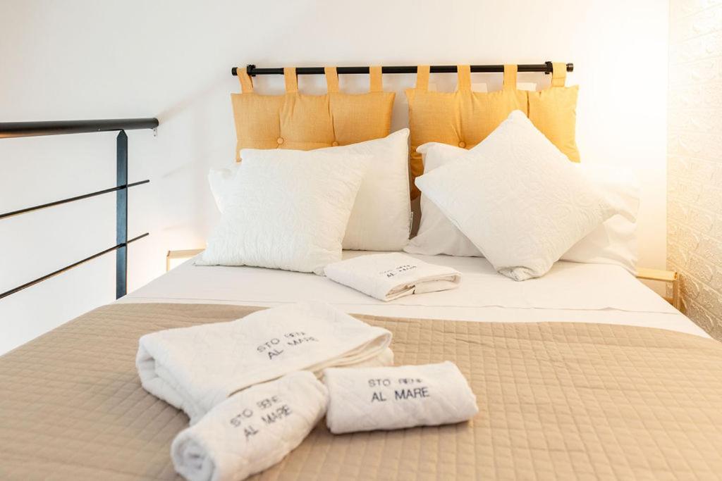 a bed with white pillows and towels on it at Sto bene al mare in Termoli