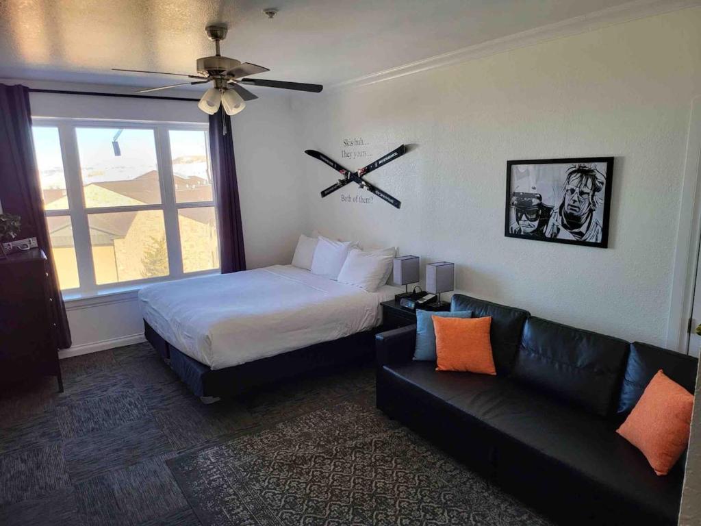 a bedroom with a bed and a couch and a window at King Bed Condo at Cedar Breaks Lodge in Brian Head