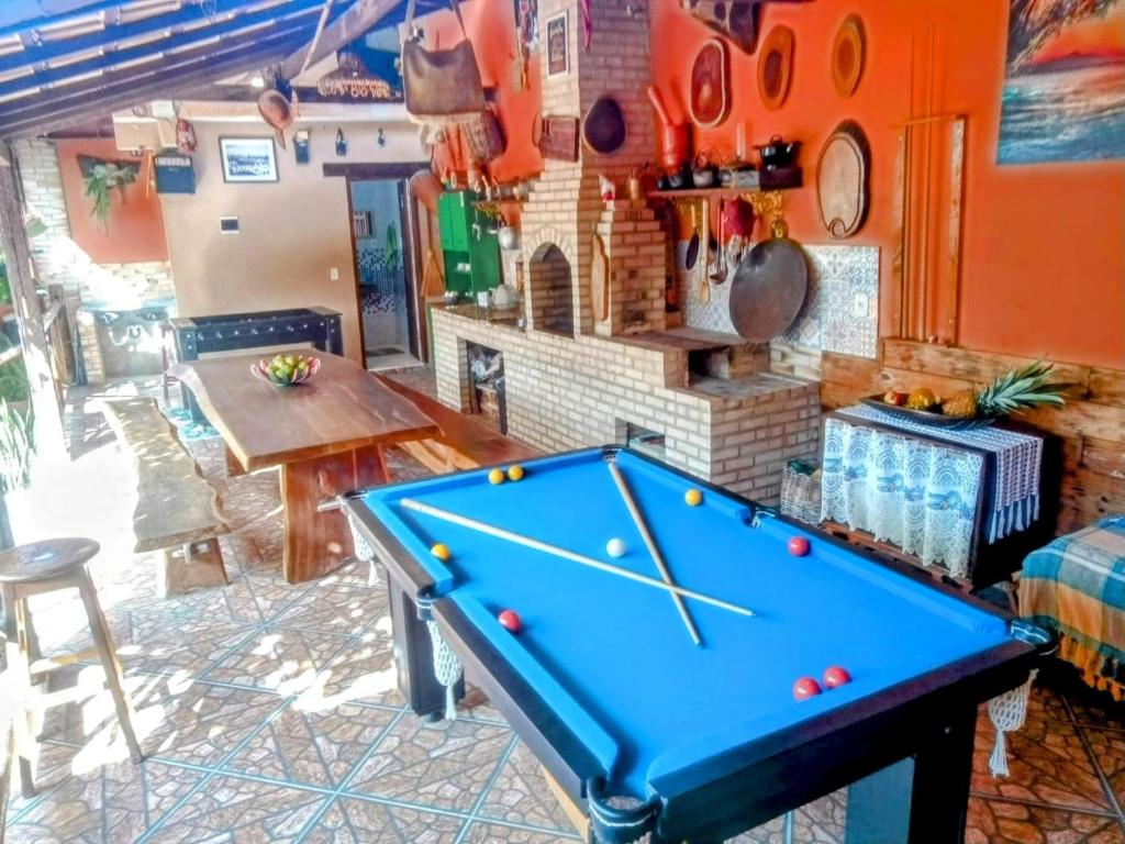 a pool table in a room with a fireplace at Rancho Magic in Cabo Frio