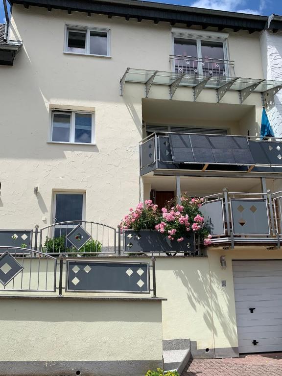 a building with balconies with flowers and a solarium at Seppel's Häuschen in Bad Orb