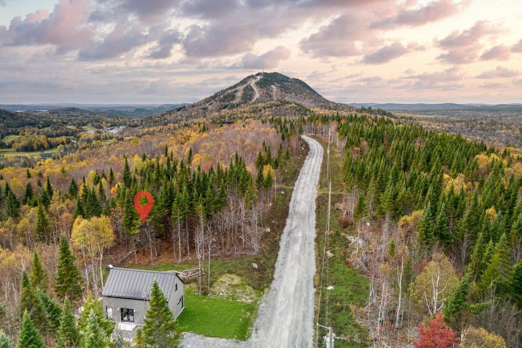 an aerial view of a mountain with a house and a road at Maison Eadda in Adstock
