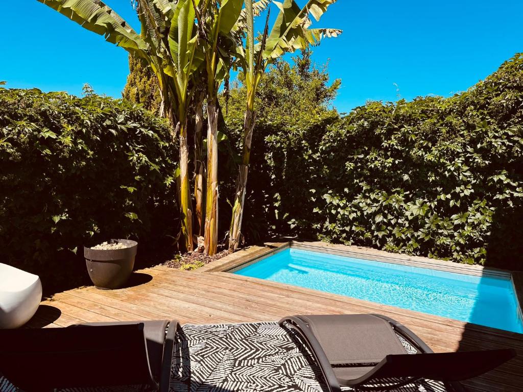 a swimming pool with two chairs next to a deck at CALME - 15 min Toulouse - PISCINE - SPA in Mons