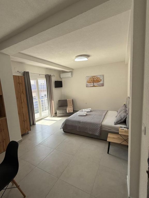 a bedroom with a bed and a chair in it at Apolana Apartments in Negotino
