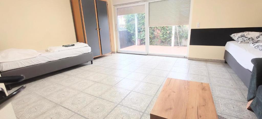 a room with two beds and a wooden table at Haus15T in Rüsselsheim