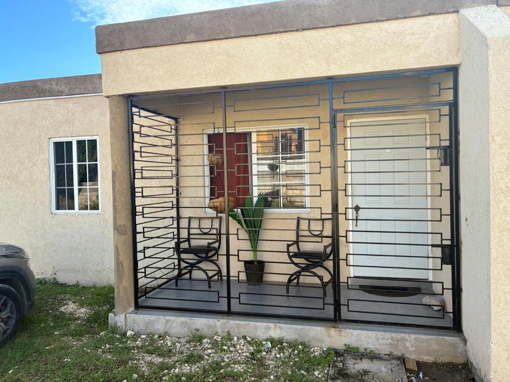 a screened in house with two chairs and a window at Grace in Spanish Town
