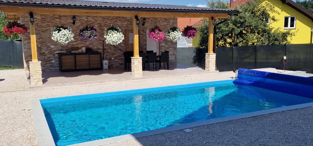 a blue swimming pool in front of a house at Villa Oaza Vilenjak in Visoko