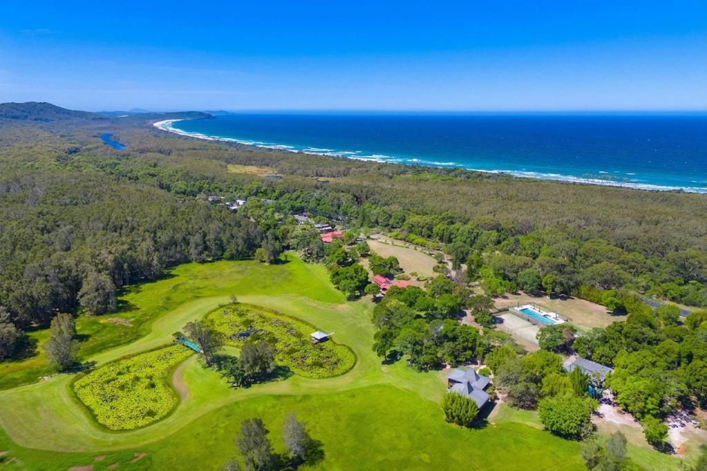 an aerial view of a golf course next to the ocean at Rancho Crescent Head in Crescent Head