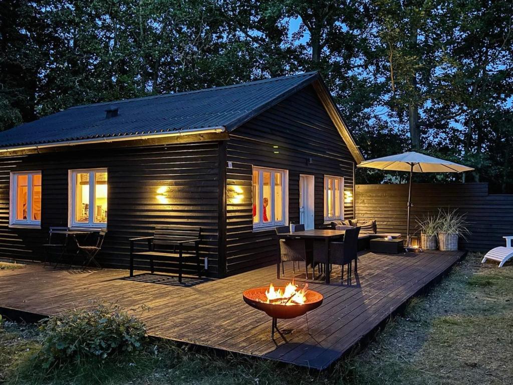 a cabin with a fire pit on a wooden deck at 4 person holiday home in Læsø-By Traum in Læsø